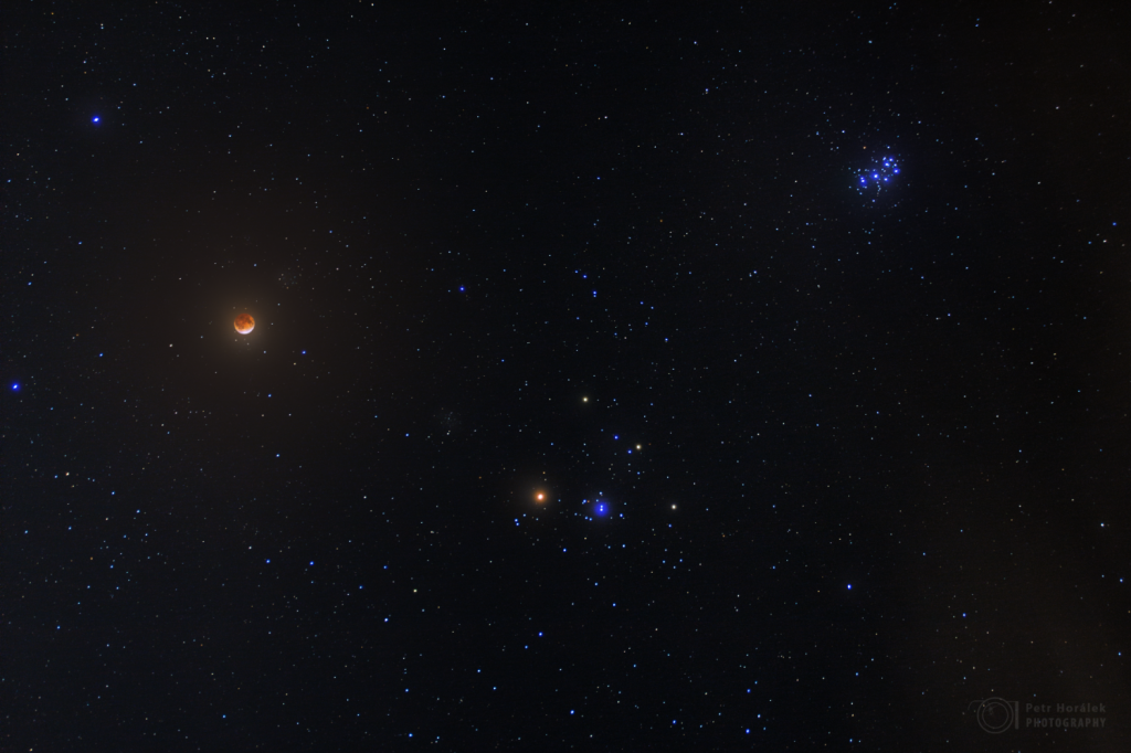 Lunar eclipse and star clusters of Taurus